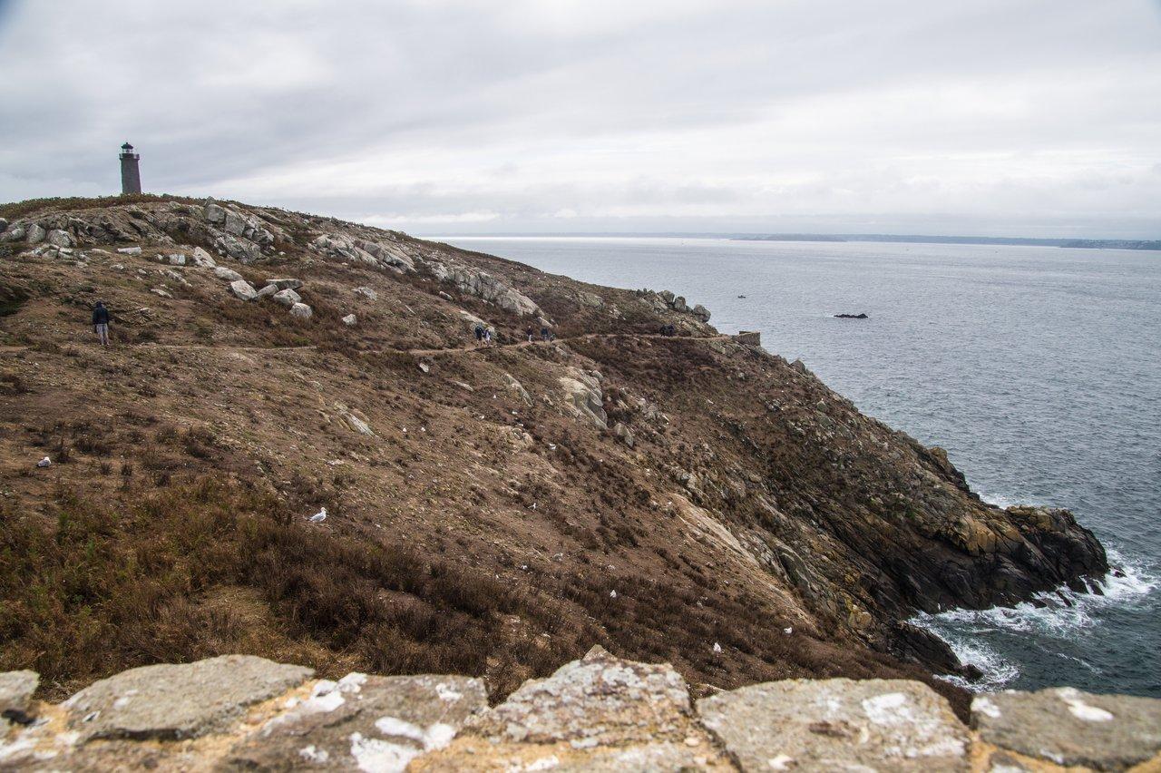 Sentier côtier du GR34 en Bretagne, falaises sauvages et lighthouse, sans touristes en hors saison.