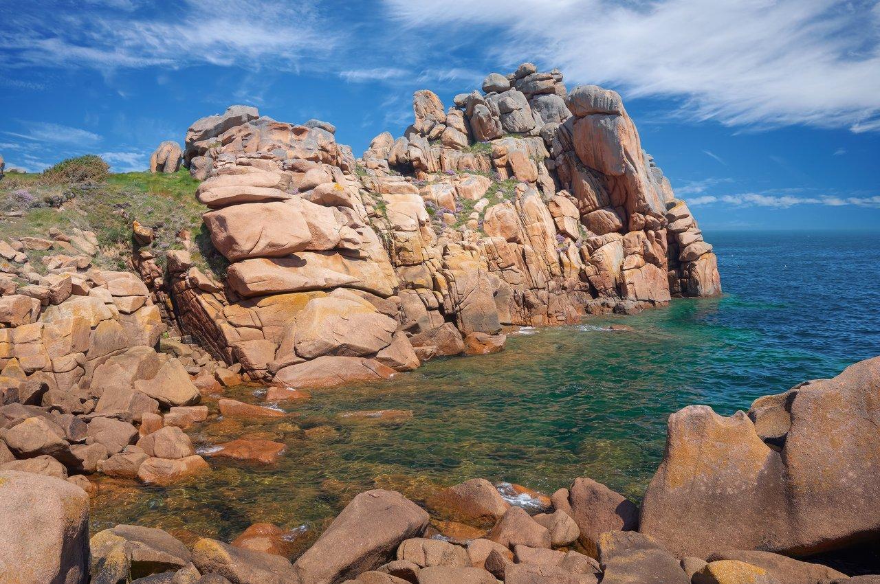 Panorama spectaculaire de la côte de granit rose, mêlant granit rose et mer turquoise en Bretagne.